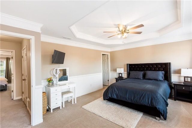 carpeted bedroom featuring a raised ceiling, crown molding, and ceiling fan