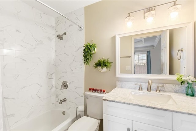 full bathroom with tiled shower / bath, vanity, and toilet