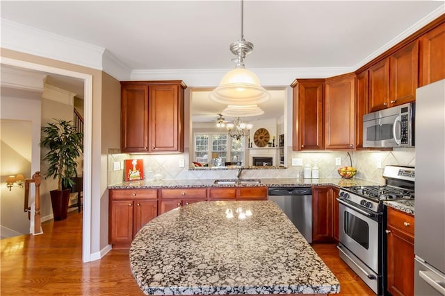 kitchen featuring hanging light fixtures, appliances with stainless steel finishes, sink, and backsplash