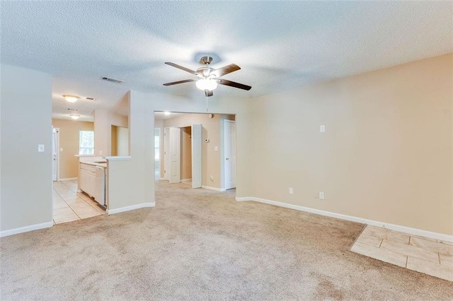 179 Glynn Addy Dr, Stockbridge, GA 30281 - empty room with light colored carpet, a ceiling fan, a textured ceiling, and light tile patterned floors