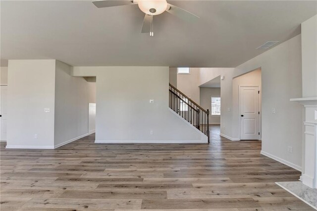 58 Longhorn Way, Auburn, GA 30011 - unfurnished living room featuring visible vents, wood finished floors, baseboards, ceiling fan, and stairway