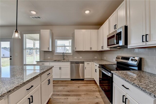 58 Longhorn Way, Auburn, GA 30011 - kitchen with white cabinets, a sink, stainless steel appliances, light wood-type flooring, and visible vents