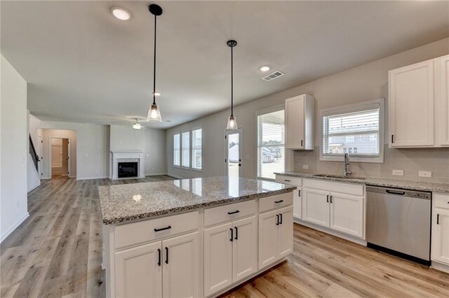 58 Longhorn Way, Auburn, GA 30011 - kitchen featuring a healthy amount of sunlight, visible vents, a fireplace, dishwasher, and a sink