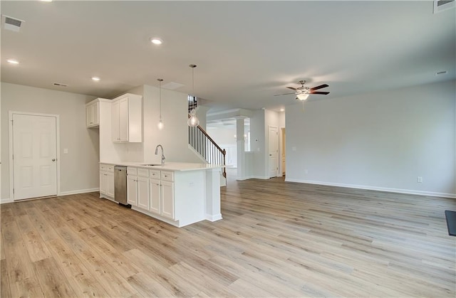 kitchen featuring ornate columns, a ceiling fan, light countertops, a sink, and open floor plan