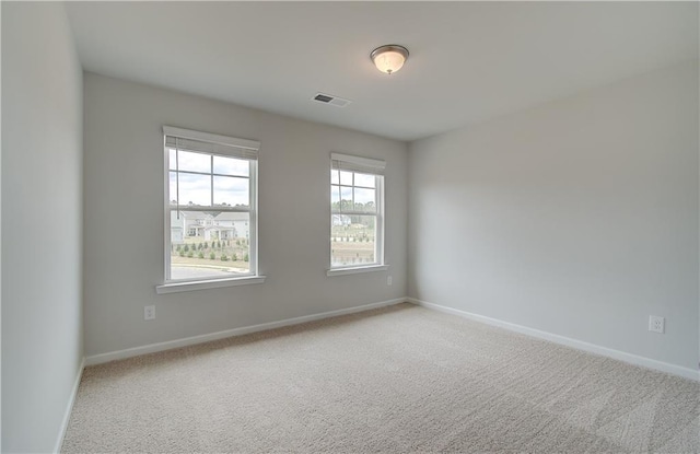 empty room featuring carpet flooring, baseboards, and visible vents