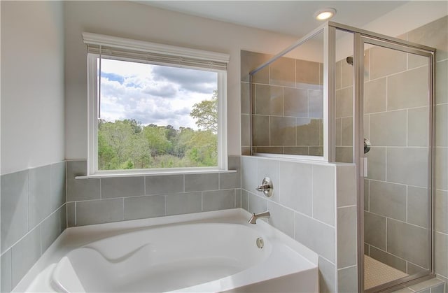 bathroom featuring a shower stall and a garden tub