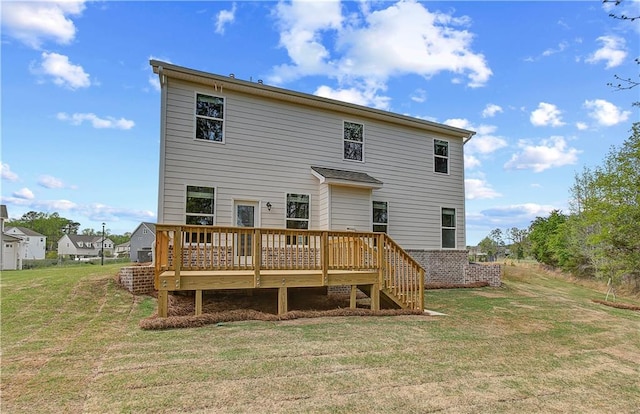 rear view of property featuring a yard and a wooden deck
