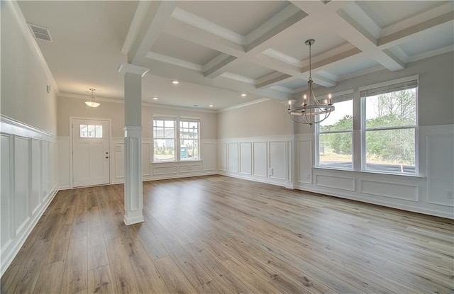 unfurnished dining area with an inviting chandelier, visible vents, beamed ceiling, decorative columns, and a decorative wall
