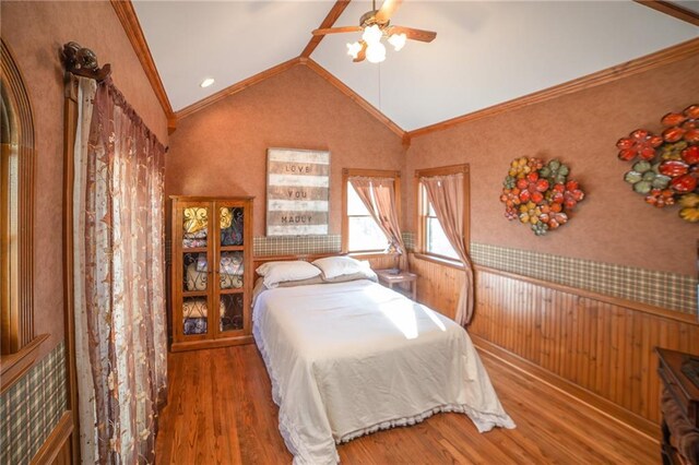 bedroom with ceiling fan, wood-type flooring, vaulted ceiling, and ornamental molding