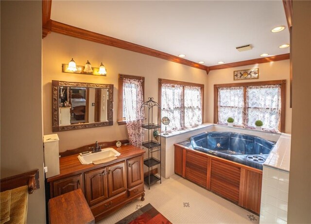 bathroom with tile patterned flooring, vanity, crown molding, and a washtub