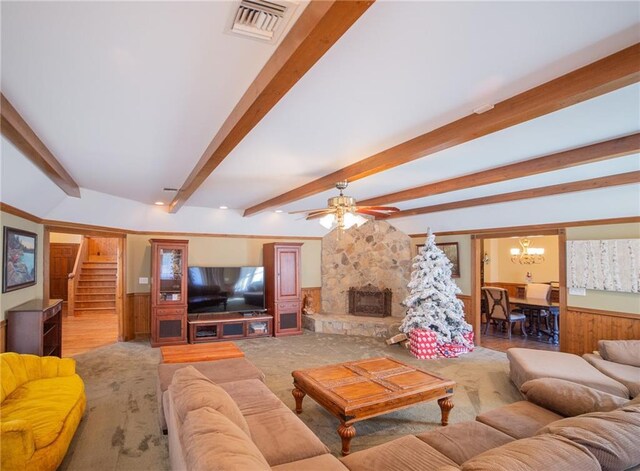 living room with beamed ceiling, ceiling fan with notable chandelier, wood walls, and a fireplace