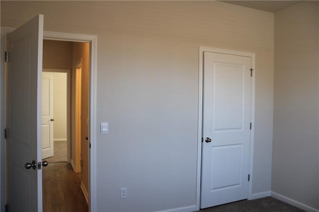 unfurnished bedroom with dark colored carpet