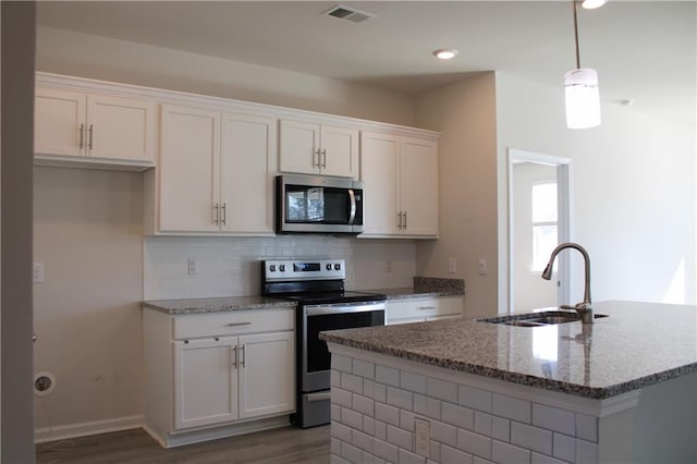 kitchen featuring sink, white cabinets, a center island with sink, and appliances with stainless steel finishes