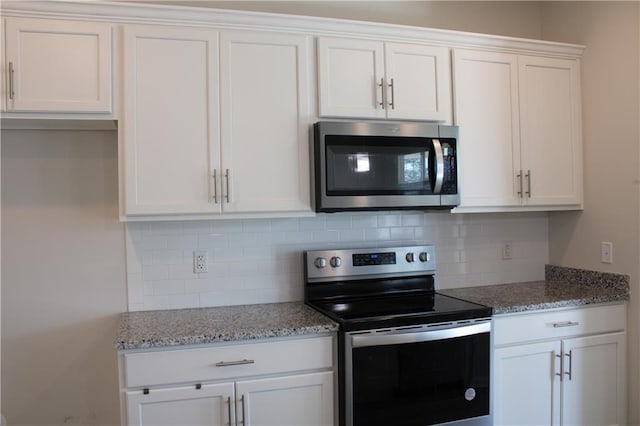 kitchen with white cabinets, decorative backsplash, and stainless steel appliances