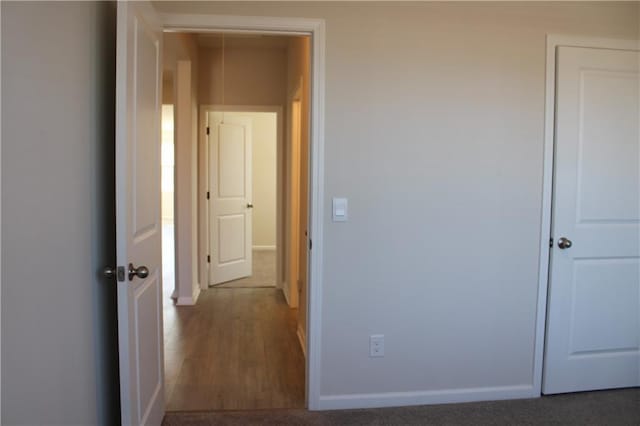 unfurnished bedroom with dark colored carpet and a closet