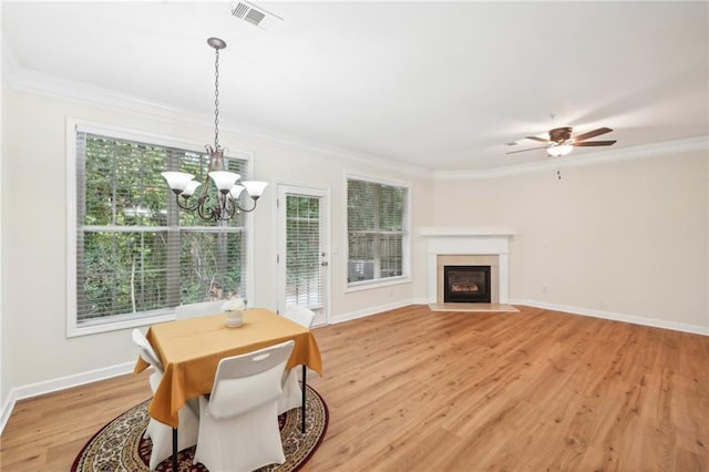 dining room with crown molding, ceiling fan with notable chandelier, and light hardwood / wood-style flooring