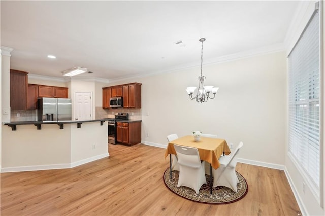 dining area featuring ornate columns, crown molding, light hardwood / wood-style flooring, and a notable chandelier