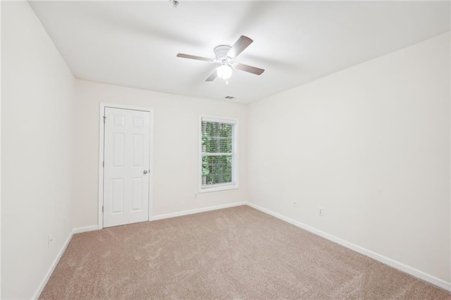 carpeted spare room featuring ceiling fan