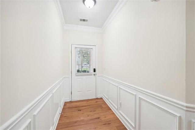 entryway with light wood-type flooring and ornamental molding