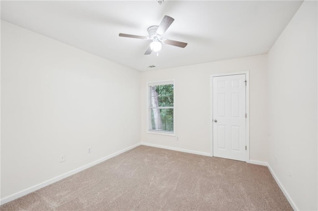 carpeted spare room with ceiling fan