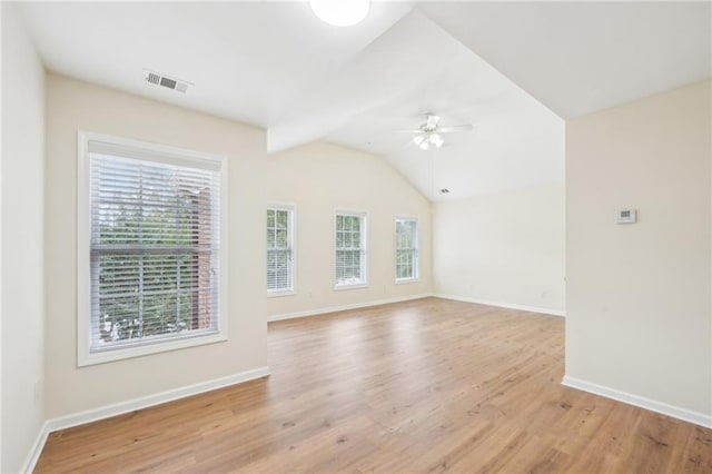 spare room featuring light wood-type flooring, vaulted ceiling, and ceiling fan