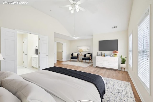 bedroom featuring lofted ceiling, multiple windows, light hardwood / wood-style floors, and ceiling fan