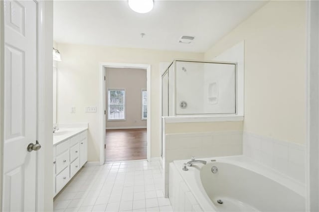 bathroom featuring independent shower and bath, vanity, and tile patterned floors