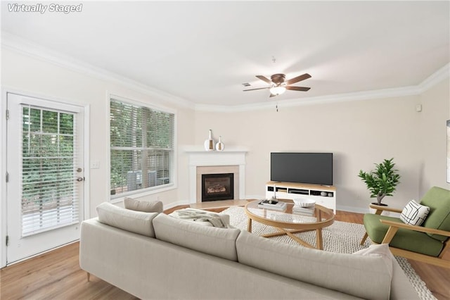 living room with ceiling fan, light hardwood / wood-style flooring, crown molding, and a healthy amount of sunlight