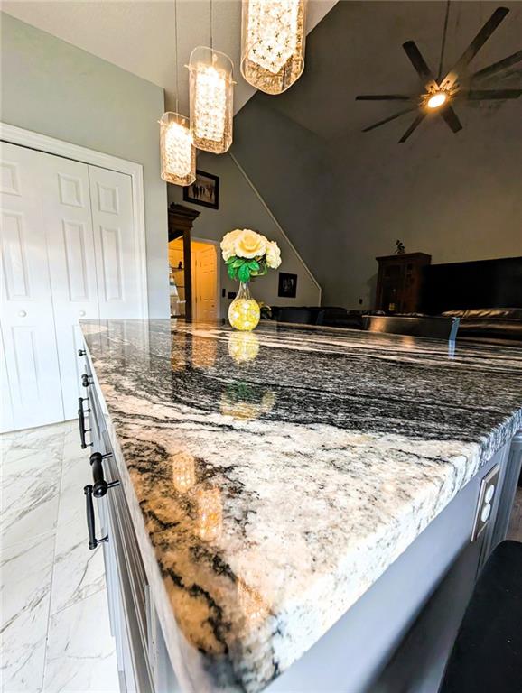 640 Dahoma Trl, Woodstock, GA 30188 - kitchen with light marble finish flooring, ceiling fan, dark stone countertops, and pendant lighting
