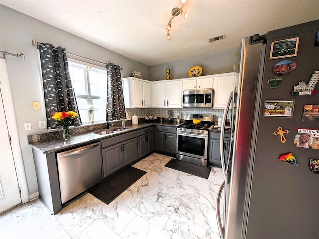 640 Dahoma Trl, Woodstock, GA 30188 - kitchen with appliances with stainless steel finishes, light marble finish floors, gray cabinetry, decorative backsplash, and white cabinets