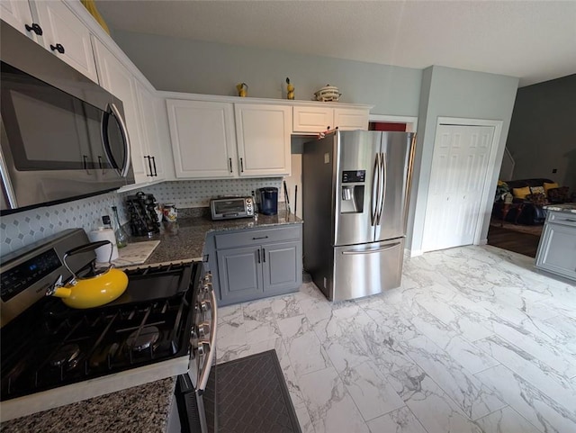640 Dahoma Trl, Woodstock, GA 30188 - kitchen featuring appliances with stainless steel finishes, light marble finish flooring, white cabinets, and dark stone counters