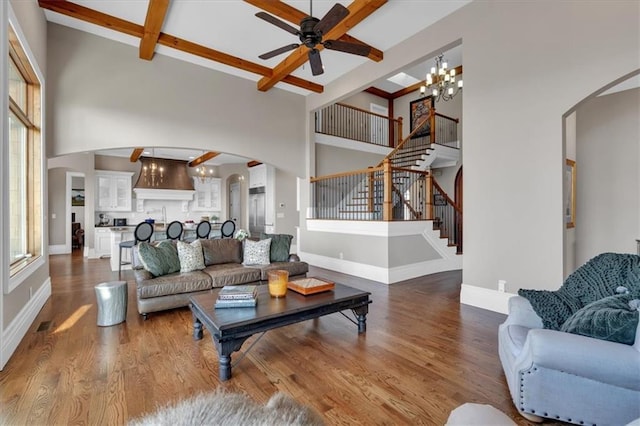 89 Somerset Ln, Cartersville, GA 30121 - living room featuring arched walkways, a chandelier, a high ceiling, a ceiling fan, and beam ceiling