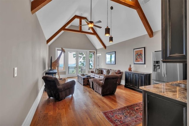 89 Somerset Ln, Cartersville, GA 30121 - living room with high vaulted ceiling, baseboards, a ceiling fan, beamed ceiling, and light wood-style floors