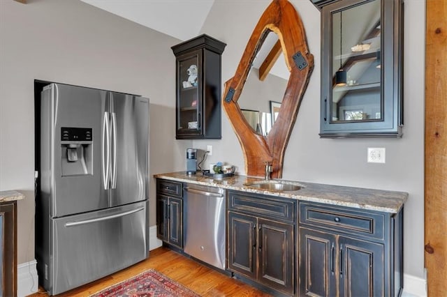 89 Somerset Ln, Cartersville, GA 30121 - kitchen featuring stainless steel appliances, a sink, light wood finished floors, glass insert cabinets, and light stone counters