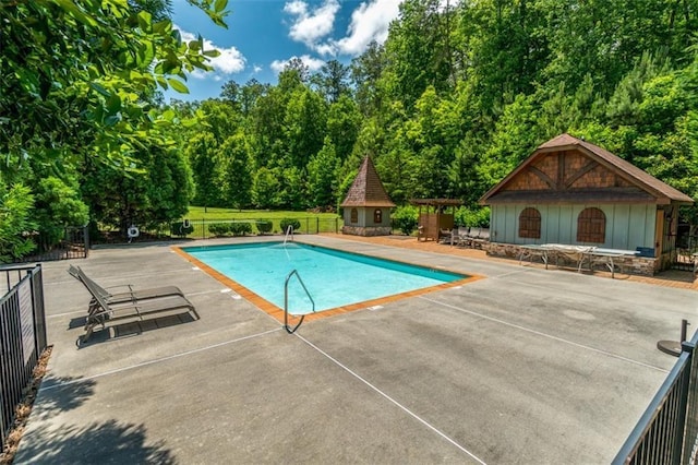 89 Somerset Ln, Cartersville, GA 30121 - view of swimming pool with a patio, an outdoor structure, a storage structure, and view of wooded area
