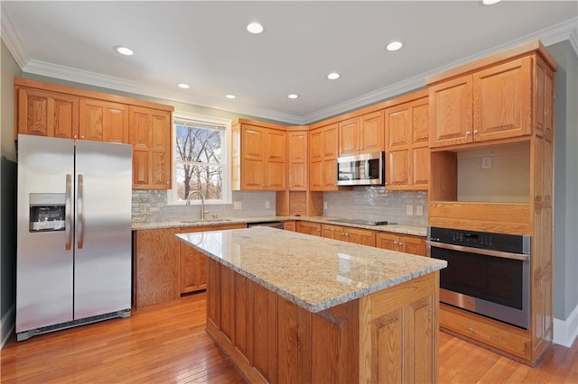 kitchen featuring sink, a kitchen island, backsplash, light hardwood / wood-style floors, and stainless steel appliances