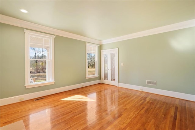 spare room featuring ornamental molding and light hardwood / wood-style flooring