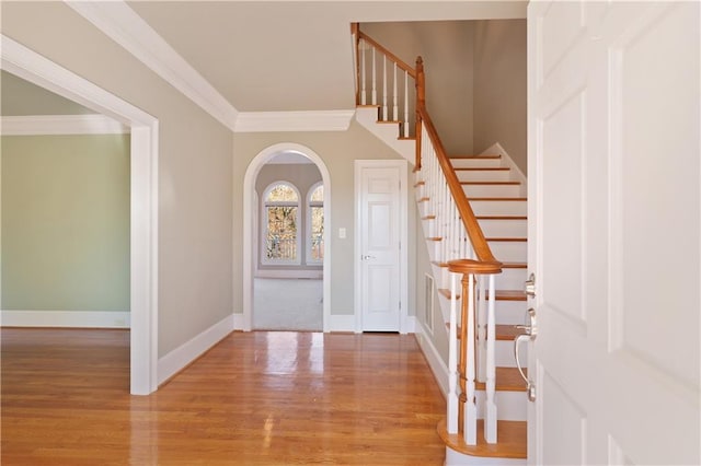 foyer entrance featuring ornamental molding and light wood-type flooring