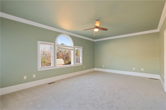 carpeted empty room featuring ceiling fan and crown molding