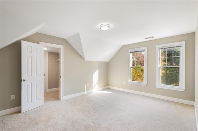 additional living space featuring light carpet and lofted ceiling