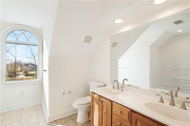 bathroom with tile flooring, double sink vanity, a wealth of natural light, and toilet