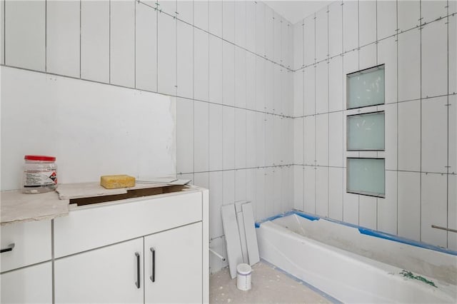 bathroom featuring tile walls and a tub to relax in