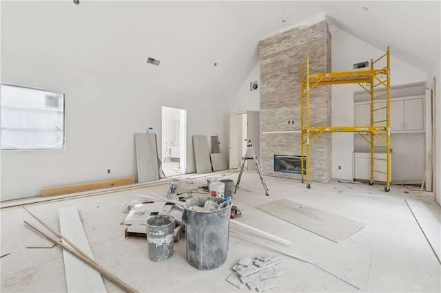 unfurnished living room with high vaulted ceiling and a fireplace