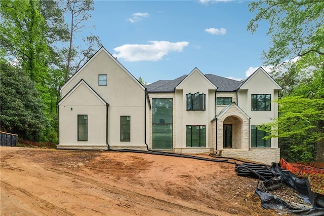 view of front of house featuring stucco siding and stone siding