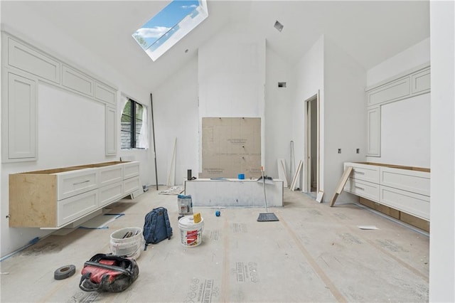 unfurnished bedroom with visible vents, a skylight, and high vaulted ceiling