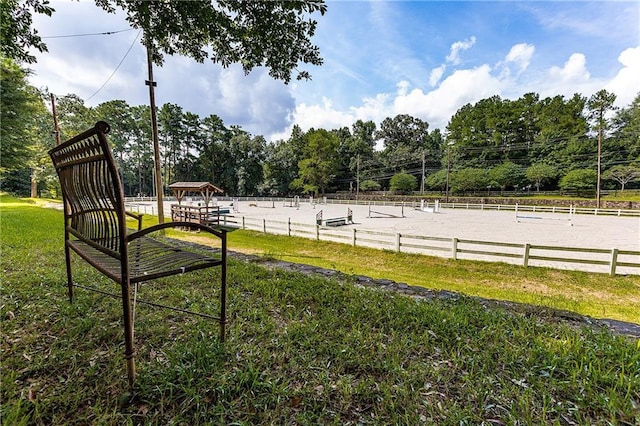 view of yard with fence and a rural view