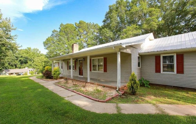 290 Timber Ridge Trl, Carrollton, GA 30117 - view of front of house featuring a chimney, a front lawn, a metal roof, and covered porch