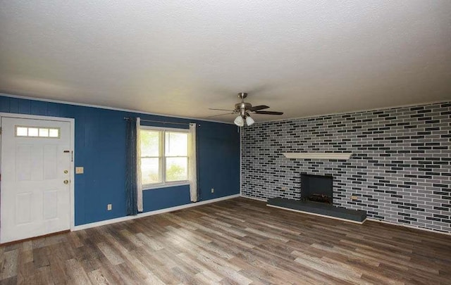 290 Timber Ridge Trl, Carrollton, GA 30117 - unfurnished living room featuring ceiling fan, wood finished floors, plenty of natural light, a large fireplace, and a textured ceiling