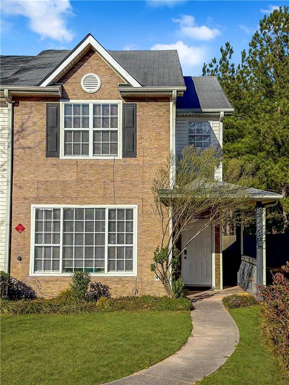 traditional-style house with a front yard and brick siding