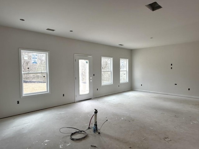 unfurnished living room featuring plenty of natural light, baseboards, and visible vents